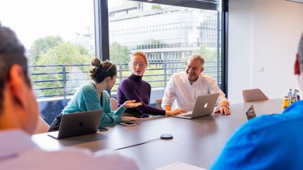 Das Team der Mainframe Entwickler spricht über ein aktuelles Softwareprojekt im Konferenzraum.