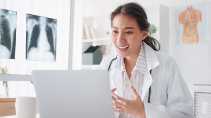 Eine Äztin führt in ihrem Behandlungszimmer eine KBV-zertifizierte Videosprechstunde mit einem Patienten über die Software kvvideo von Akquinet durch.