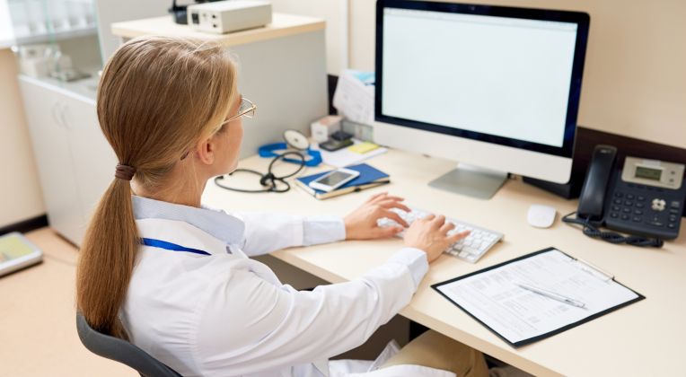 Eine junge Ärztin nutzt den ePA-Client von AKQUINET für einen einfachen Zugriff auf die elektronische Patientenakte